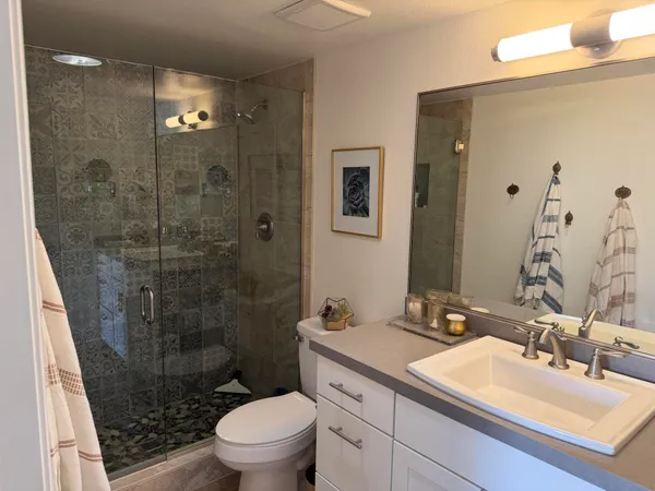 a bathroom with a sink a toilet and shower