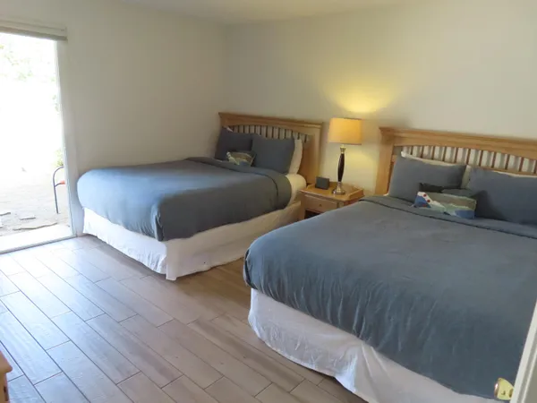 a bedroom with two beds and painting on the wall