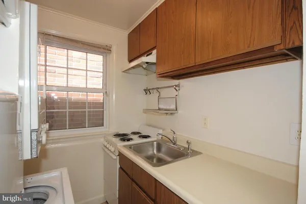 a kitchen with a sink a stove and cabinets