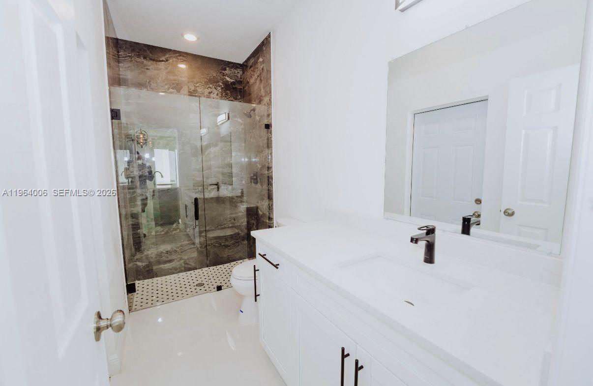 4405 East 7th Street Lehigh Acres, FL 33972 - Photo 2 of 6 a bathroom with a shower sink and mirror