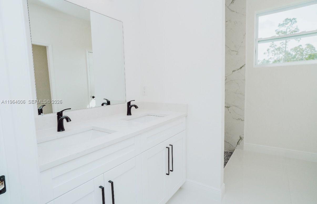 4405 East 7th Street Lehigh Acres, FL 33972 - Photo 4 of 6 a bathroom with a sink and a mirror