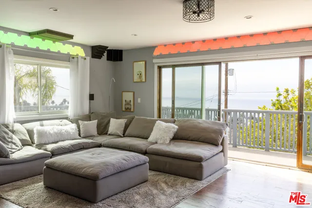 a living room with furniture and a floor to ceiling window