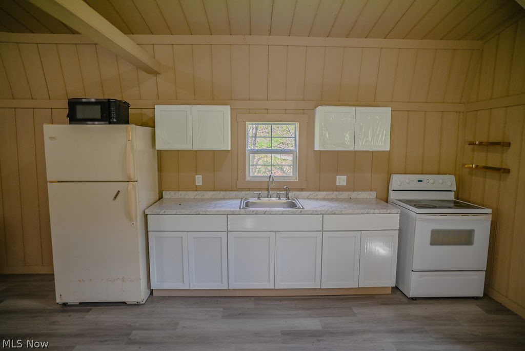 1547 Providence Road Elizabeth, WV 26143 - Photo 6 of 32 Compact kitchen area featuring wood-finish flooring, white cabinetry, a single basin sink, and a window