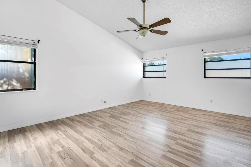 5720 West Waterford Drive Davie, FL 33331 - Photo 17 of 25 an empty room with wooden floor fan and windows