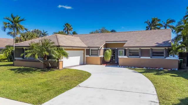 a front view of a house with a yard and potted plants
