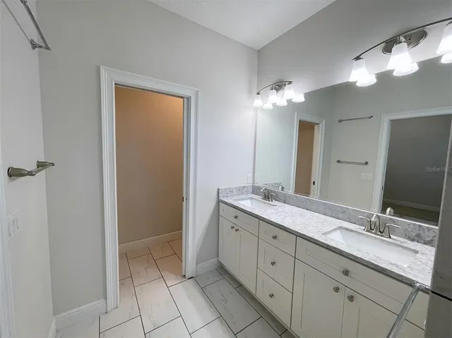 a bathroom with a double vanity sink and a mirror
