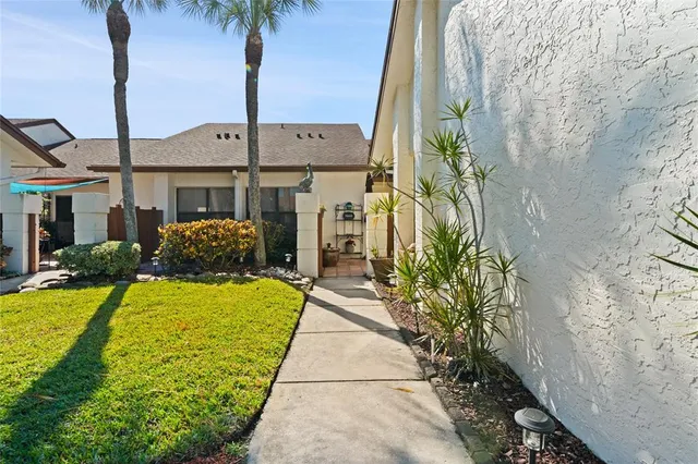 a front view of a house with a yard and potted plants