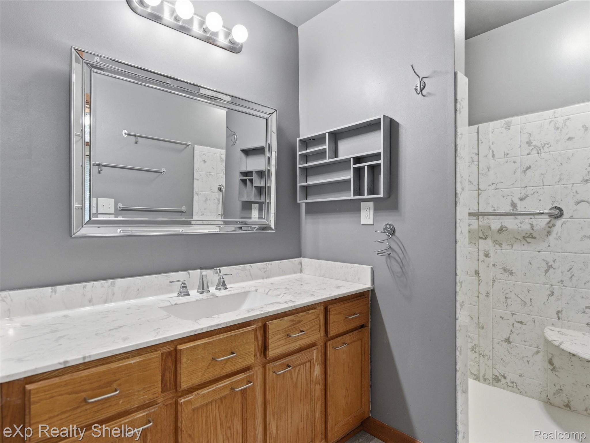 4154 Union Street Dryden, MI 48428 - Photo 22 of 41 Bathroom vanity featuring a light wood-finish cabinet with silver hardware, a white countertop with an integrated sink, and a chrome-finish faucet