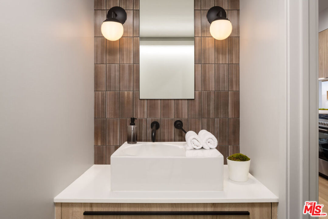 12431 Rochester Avenue, Unit PH4 Los Angeles, CA 90025 - Photo 16 of 28 a bathroom with a sink mirror and vanity