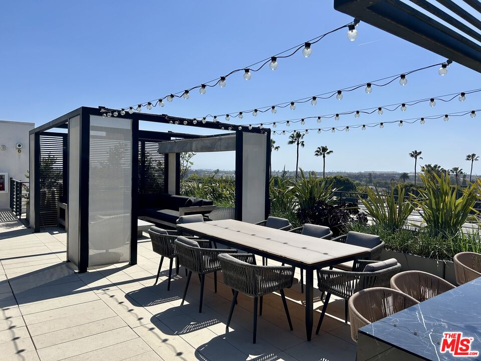 12431 Rochester Avenue, Unit PH4 Los Angeles, CA 90025 - Photo 27 of 28 a view of a patio with table and chairs and potted plants