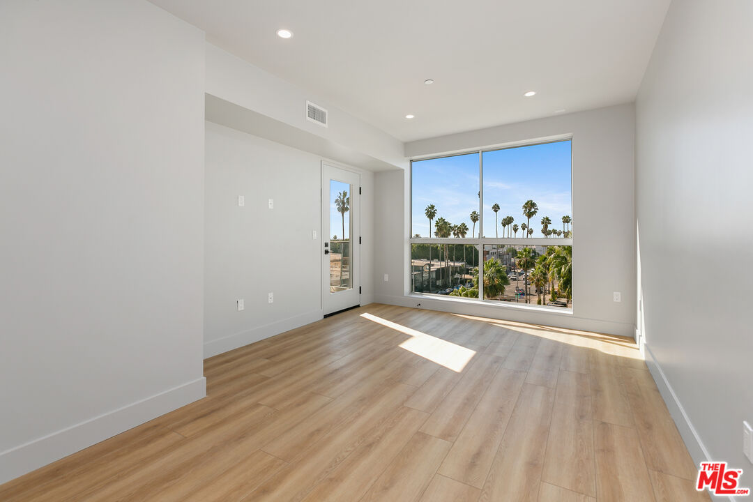 12431 Rochester Avenue, Unit PH4 Los Angeles, CA 90025 - Photo 4 of 28 a view of an empty room with a window and wooden floor
