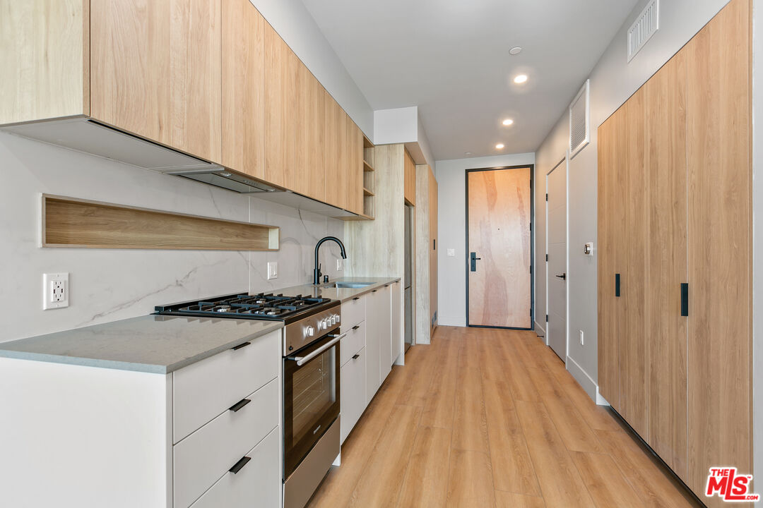 12431 Rochester Avenue, Unit PH4 Los Angeles, CA 90025 - Photo 7 of 28 a kitchen with stainless steel appliances granite countertop a stove and a refrigerator