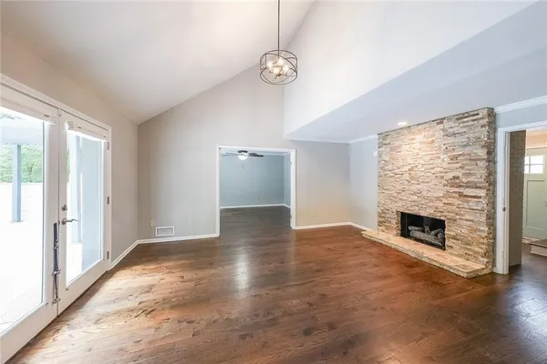 a view of empty room with fireplace and wooden floor