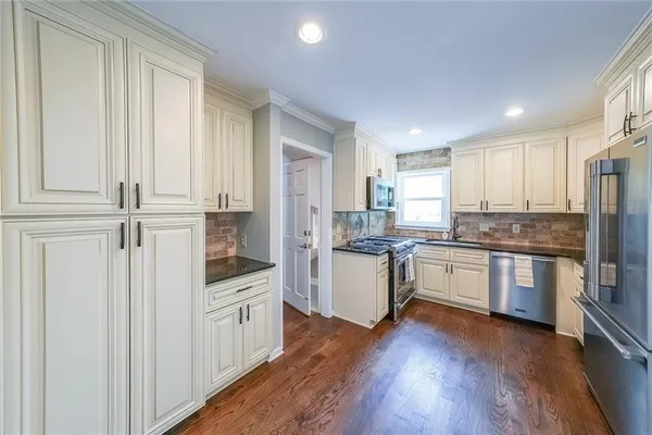 a kitchen with granite countertop white cabinets and white appliances