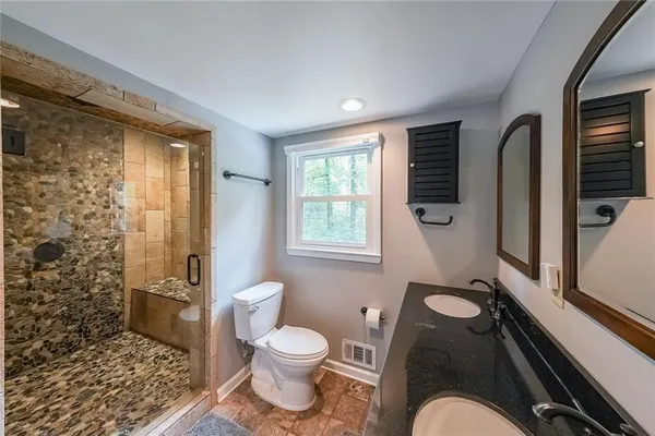 a bathroom with a granite countertop toilet sink and shower