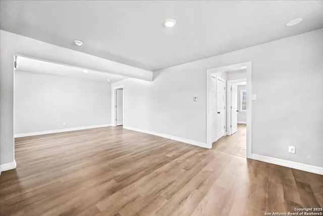 a view of an empty room with wooden floor