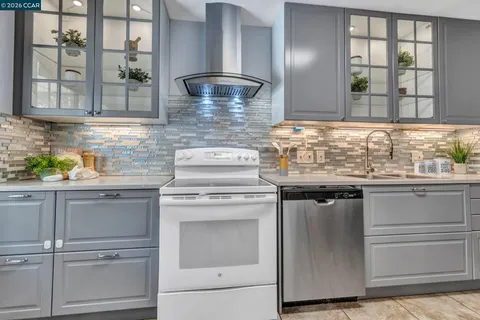 a kitchen with granite countertop stainless steel appliances white cabinets and a granite counter tops