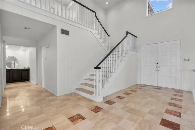 an empty room with windows fireplace and wooden floor