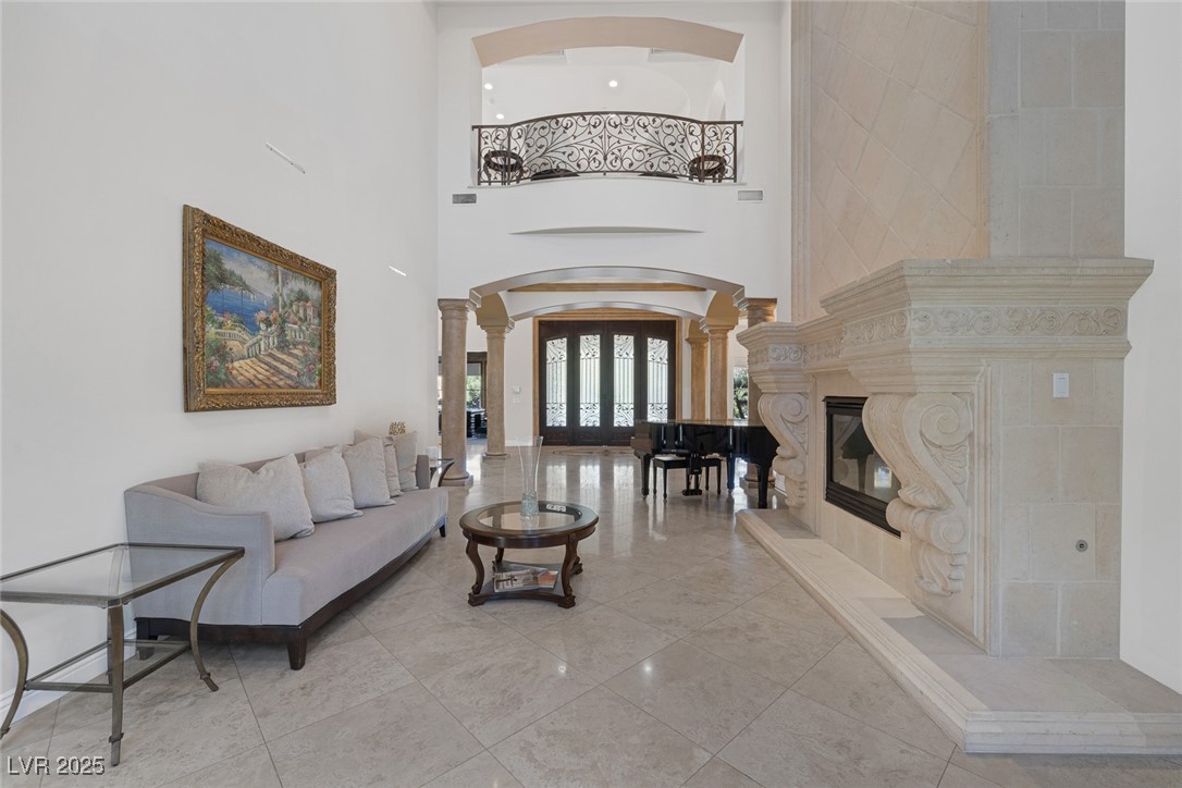 1545 Villa Rica Drive Henderson, NV 89052 - Photo 11 of 61 Living area with ornate columns, french doors, arched walkways, a premium fireplace, and a towering ceiling