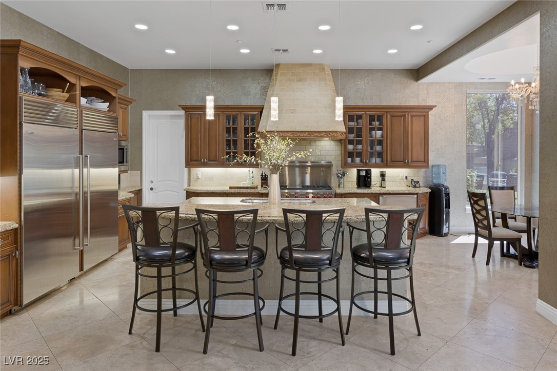 1545 Villa Rica Drive Henderson, NV 89052 - Photo 18 of 61 Kitchen with recessed lighting, built in fridge, a center island with sink, a breakfast bar area, and light stone countertops