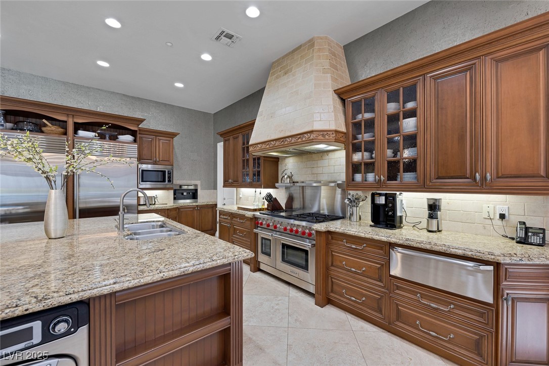 1545 Villa Rica Drive Henderson, NV 89052 - Photo 20 of 61 Kitchen featuring a warming drawer, backsplash, recessed lighting, light stone counters, and light tile patterned floors