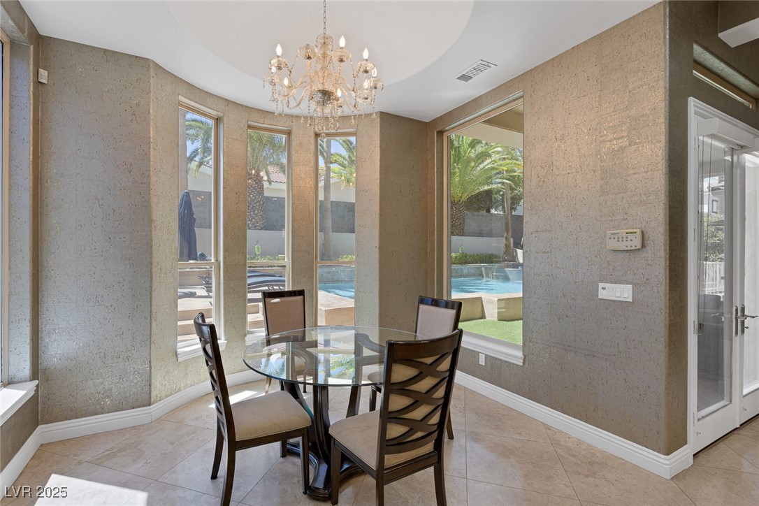 1545 Villa Rica Drive Henderson, NV 89052 - Photo 23 of 61 Dining room with wallpapered walls, a chandelier, and light tile patterned floors