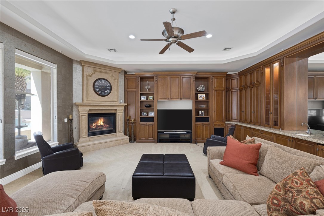 1545 Villa Rica Drive Henderson, NV 89052 - Photo 25 of 61 Living area featuring a premium fireplace, ceiling fan, a raised ceiling, recessed lighting, and light carpet
