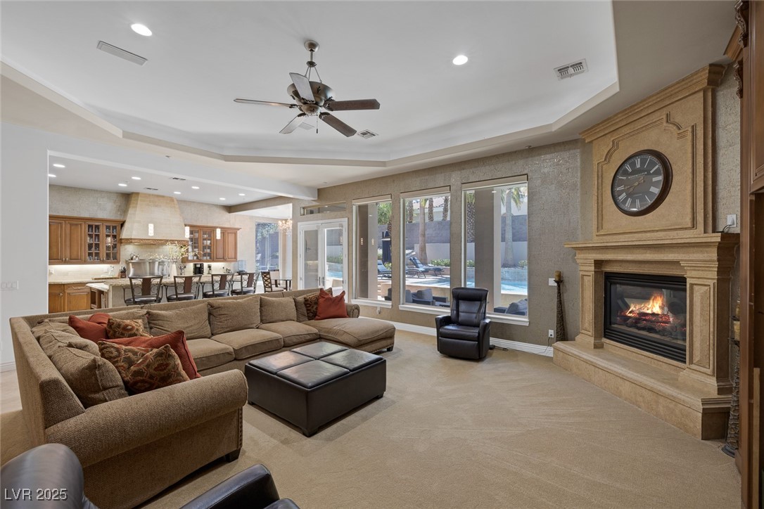 1545 Villa Rica Drive Henderson, NV 89052 - Photo 26 of 61 Living area with a fireplace, recessed lighting, a ceiling fan, a tray ceiling, and light colored carpet