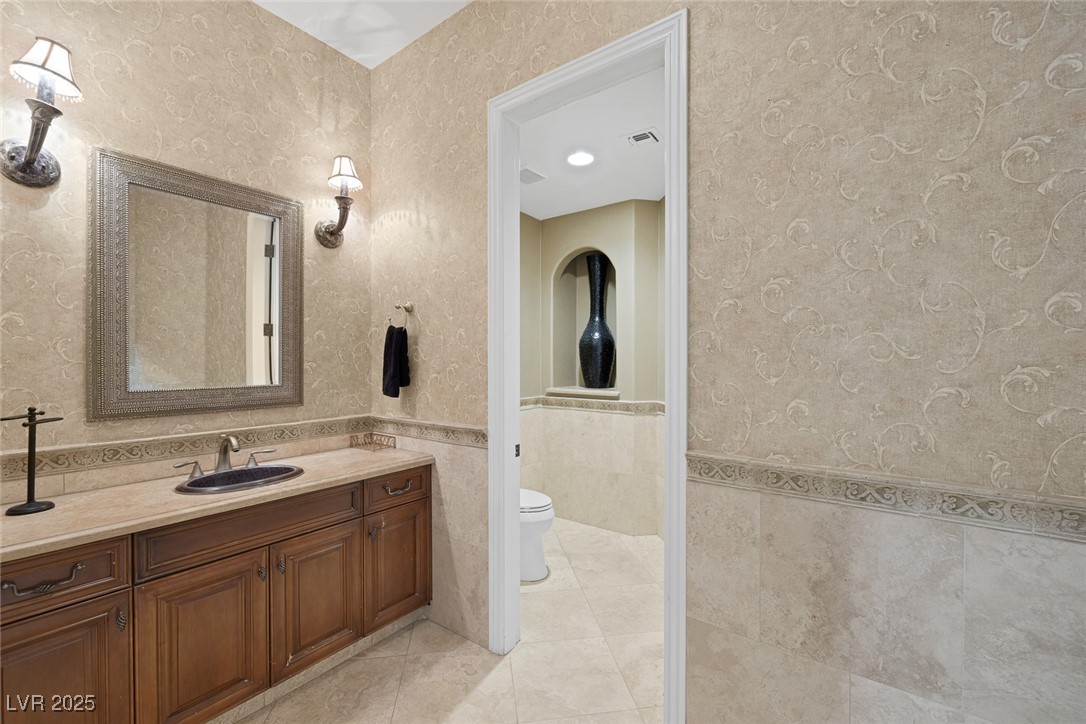 1545 Villa Rica Drive Henderson, NV 89052 - Photo 28 of 61 Full bath with tile walls, a wainscoted wall, vanity, tile patterned floors, and recessed lighting