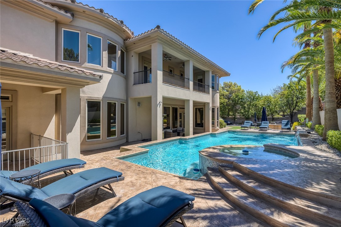 1545 Villa Rica Drive Henderson, NV 89052 - Photo 49 of 61 Back of house featuring a balcony, a pool with connected hot tub, a tiled roof, a patio, and stucco siding