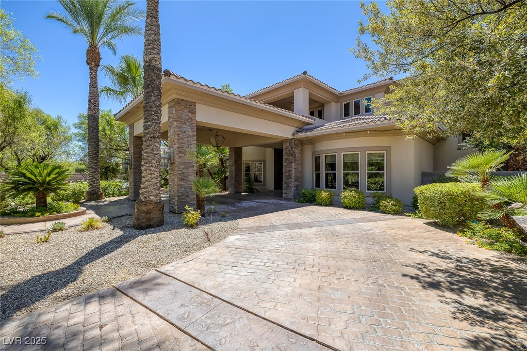 1545 Villa Rica Drive Henderson, NV 89052 - Photo 52 of 61 View of front of property with stucco siding, stone siding, curved driveway, and a tile roof