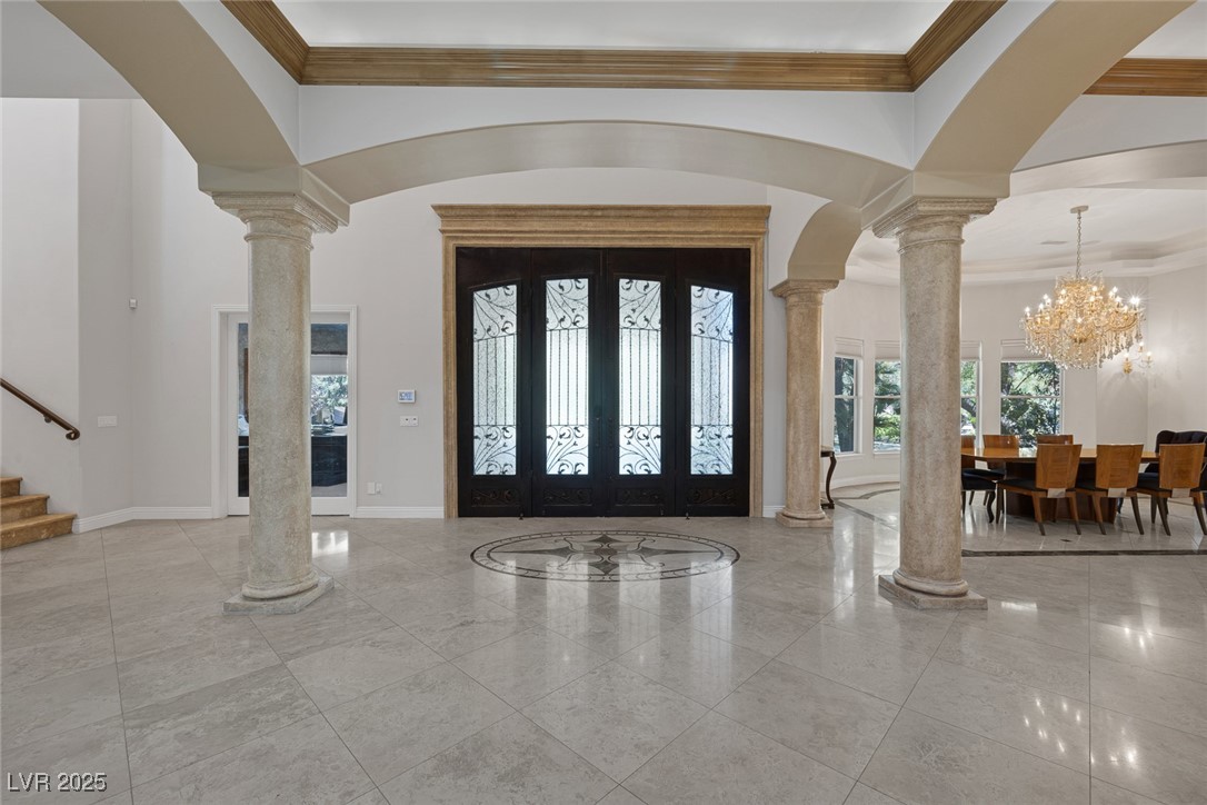 1545 Villa Rica Drive Henderson, NV 89052 - Photo 6 of 61 Foyer with ornate columns, ornamental molding, a chandelier, stairs, and arched walkways