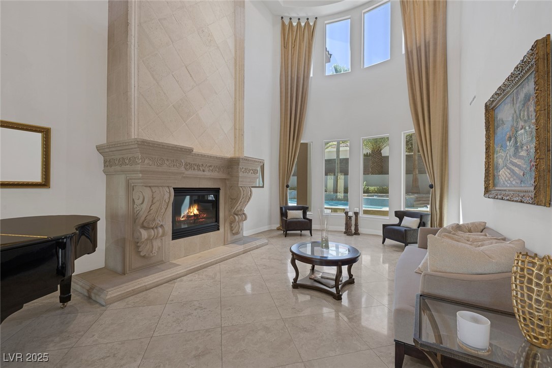 1545 Villa Rica Drive Henderson, NV 89052 - Photo 10 of 61 Living room featuring a fireplace, a high ceiling, and tile patterned flooring