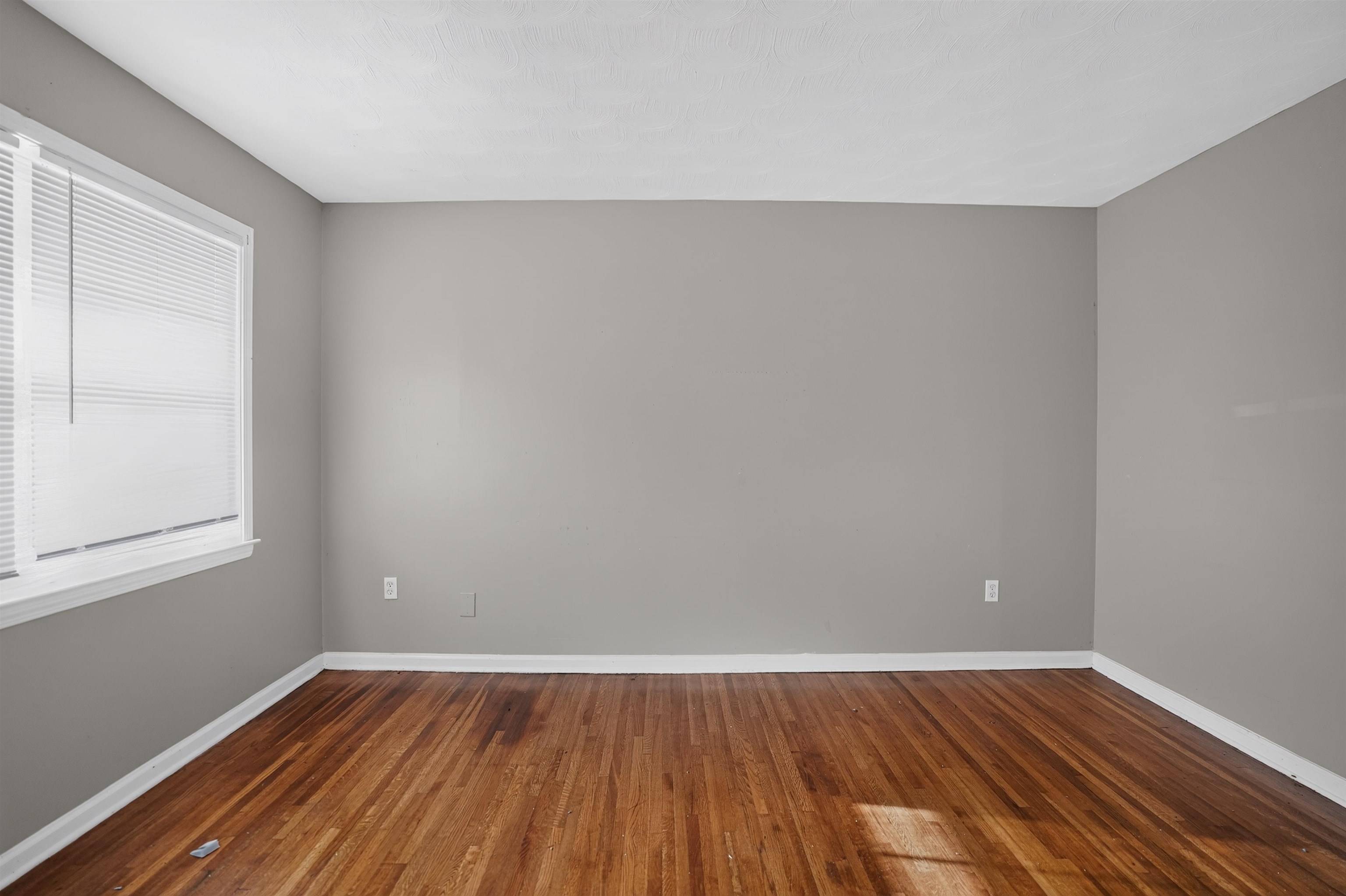3736 Range Line Road Memphis, TN 38127 - Photo 4 of 18 Room featuring wood-finish flooring, light gray walls, white trim, and a window with blinds