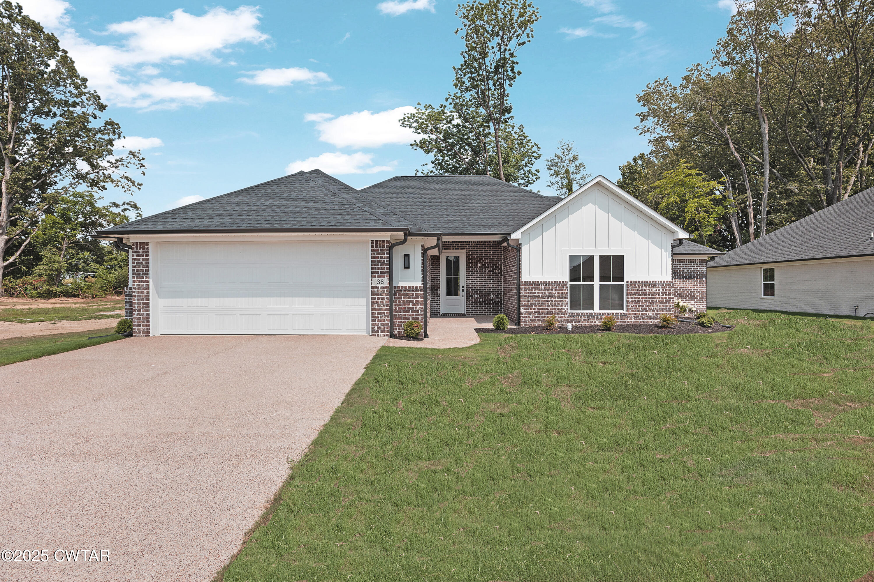 a view of a house with a big yard potted plants and large tree