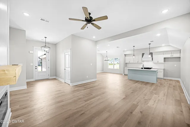 a view of kitchen with stainless steel appliances kitchen island hardwood floor and a sink