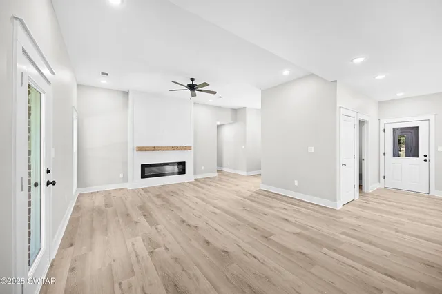 a view of empty room with wooden floor and window