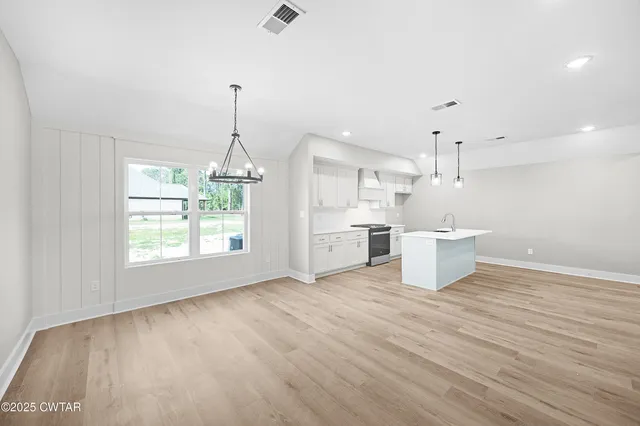 a view of a kitchen with wooden floor and windows