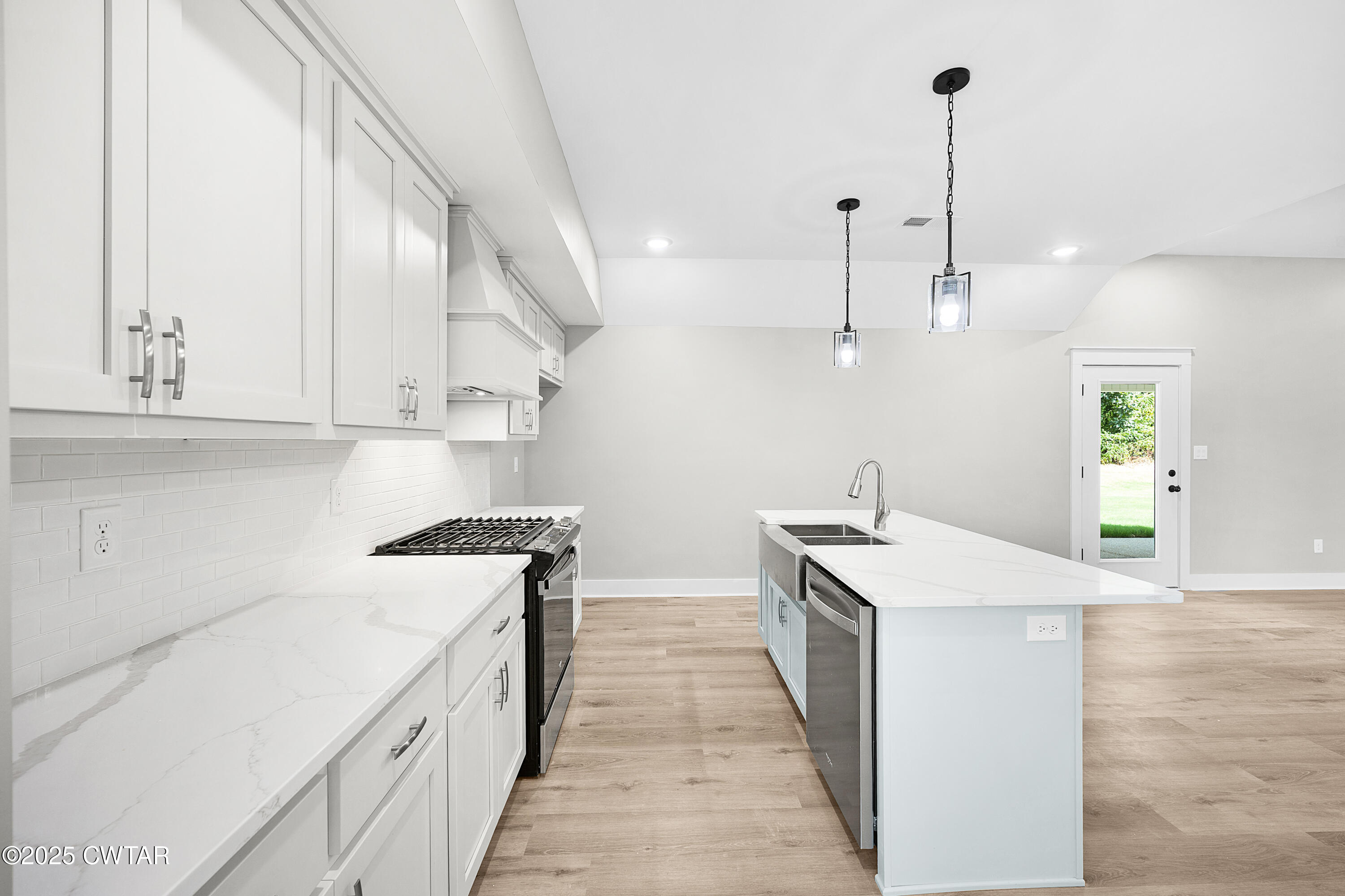 36 Grande Pnes Cove Jackson, TN 38305 - Photo 9 of 23 a kitchen with stainless steel appliances granite countertop a sink a stove and a wooden floors