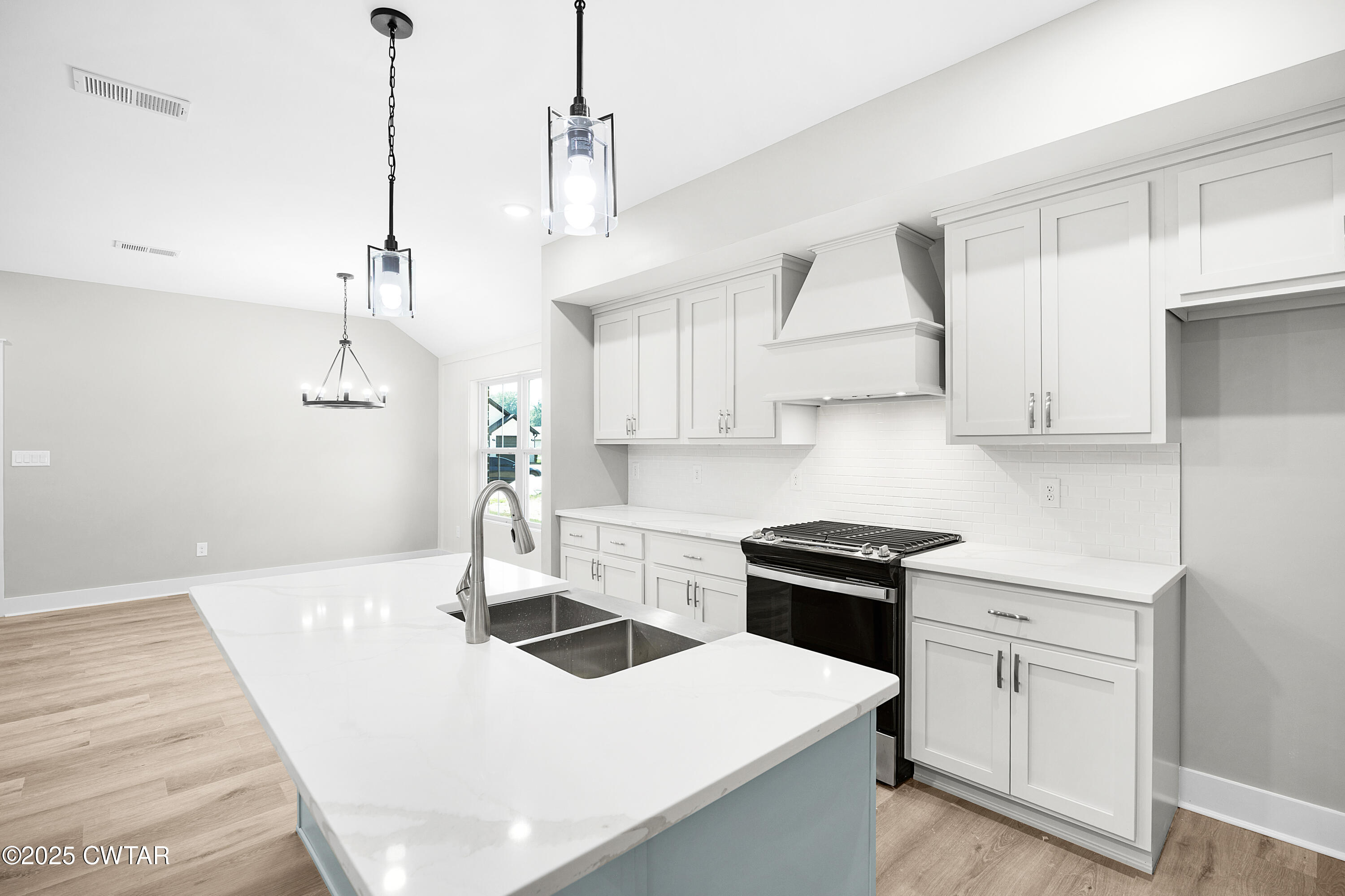36 Grande Pnes Cove Jackson, TN 38305 - Photo 10 of 23 a kitchen with kitchen island a sink a stove and white cabinets