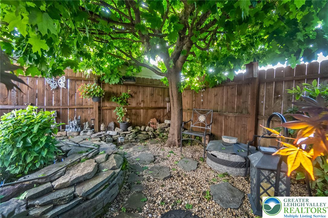 365 Rock Street Easton, PA 18042 - Photo 49 of 50 A tranquil garden oasis awaits, featuring a stone water feature, mature shade tree, and fenced perimeter.