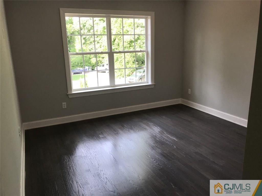 140 Dover Road Colonia, NJ 07067 - Photo 3 of 14 an empty room with wooden floor and windows