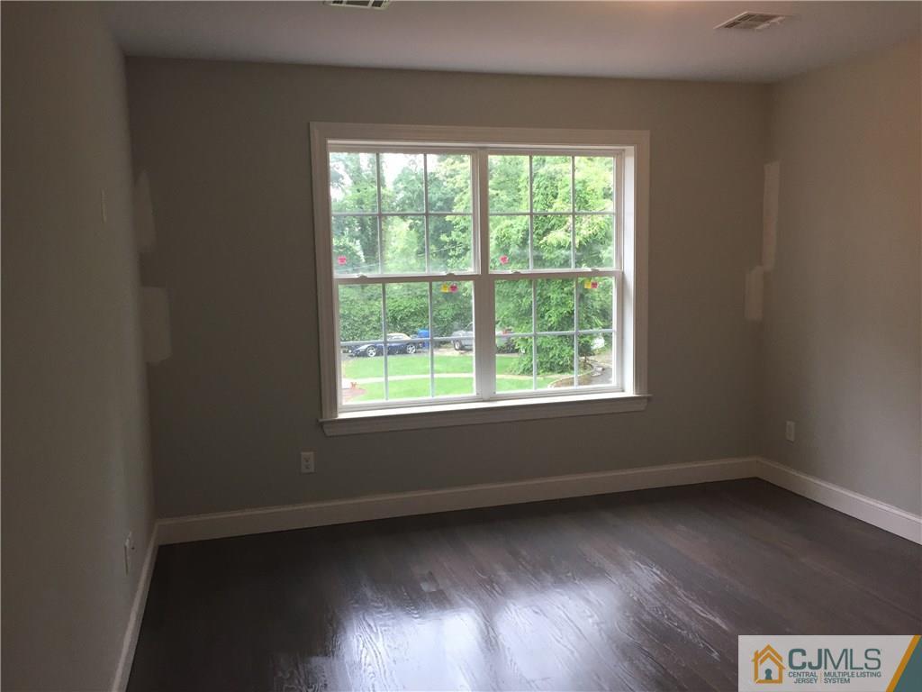 140 Dover Road Colonia, NJ 07067 - Photo 7 of 14 an empty room with wooden floor and windows