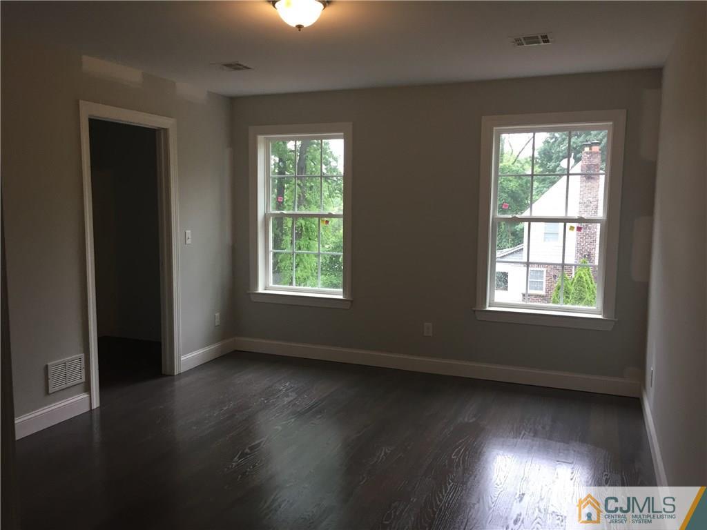 140 Dover Road Colonia, NJ 07067 - Photo 9 of 14 an empty room with wooden floor and windows