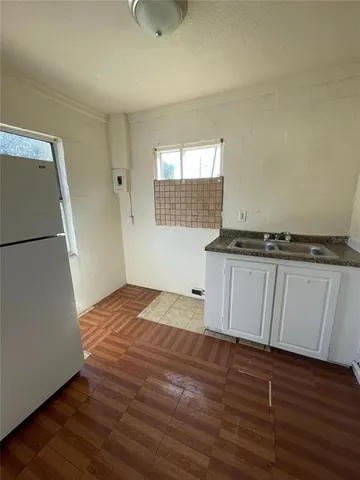 a view of a kitchen with a sink and dishwasher wooden floor