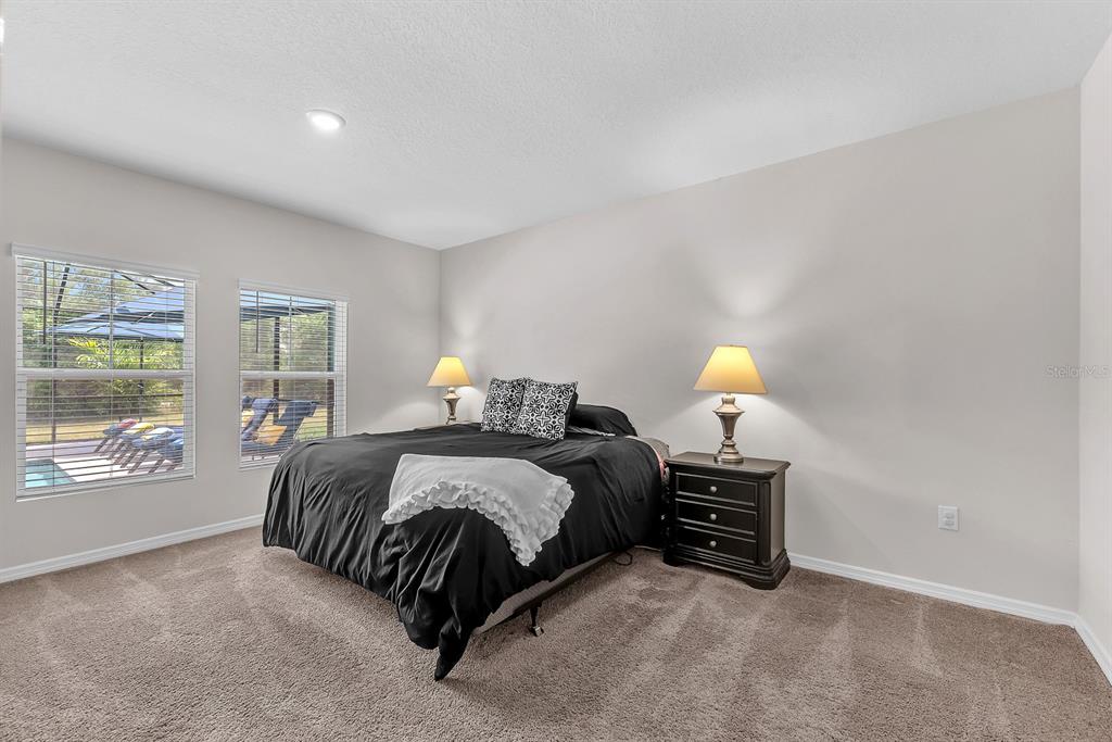 12952 Wellspring Drive Lithia, FL 33547 - Photo 14 of 46 a bedroom with a bed lamp and window