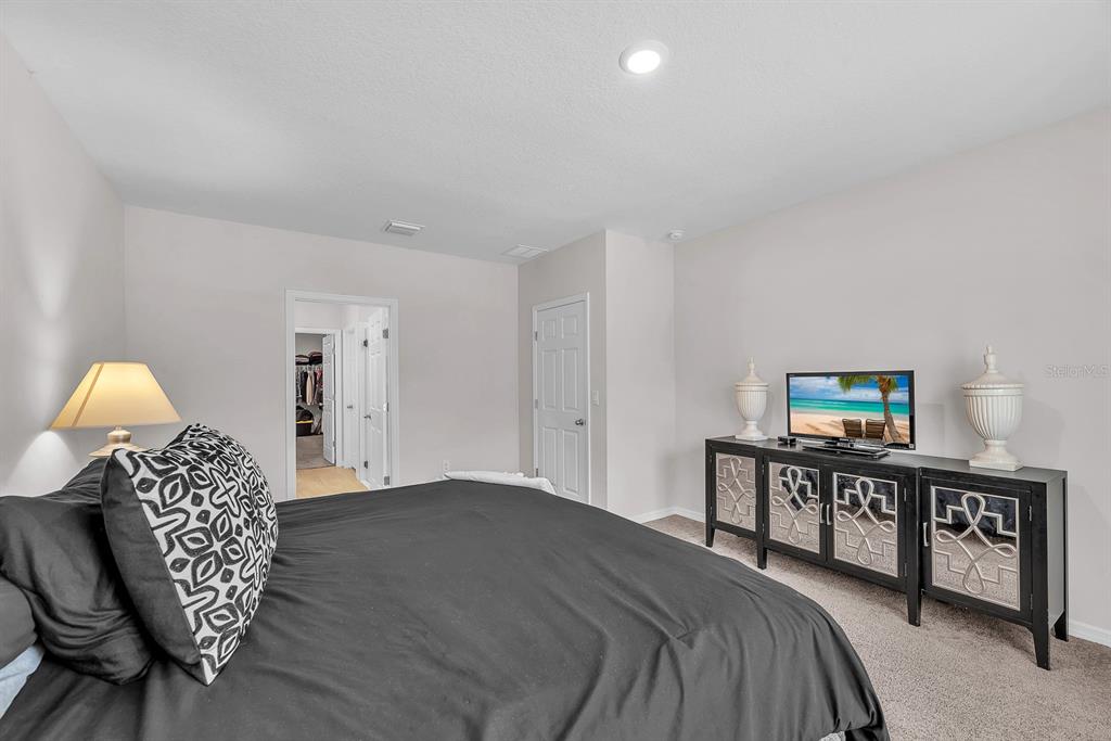 12952 Wellspring Drive Lithia, FL 33547 - Photo 16 of 46 a bedroom with a bed a dresser and chair