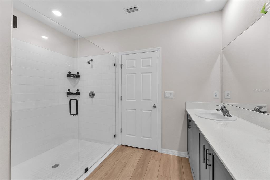 12952 Wellspring Drive Lithia, FL 33547 - Photo 18 of 46 a bathroom with a granite countertop sink a mirror and shower