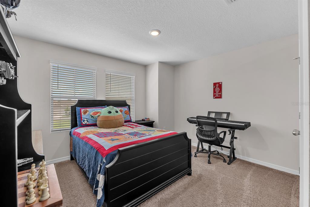 12952 Wellspring Drive Lithia, FL 33547 - Photo 24 of 46 a bedroom with a bed and a table in it
