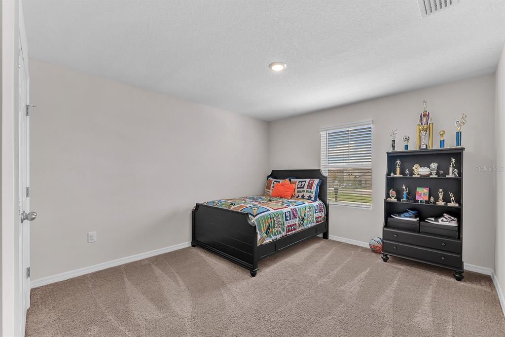 12952 Wellspring Drive Lithia, FL 33547 - Photo 25 of 46 a living room with furniture a bookshelf and a window